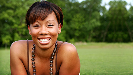 A beautiful woman smiling after receiving LANAP (Laser-Assisted New Attachment Procedure) treatment for periodontal disease at the Dental Excellence Centre for Cosmetic, Laser, and Implant Dentistry. Her gums appear healthy and rejuvenated, showcasing the effectiveness of laser periodontal treatment.